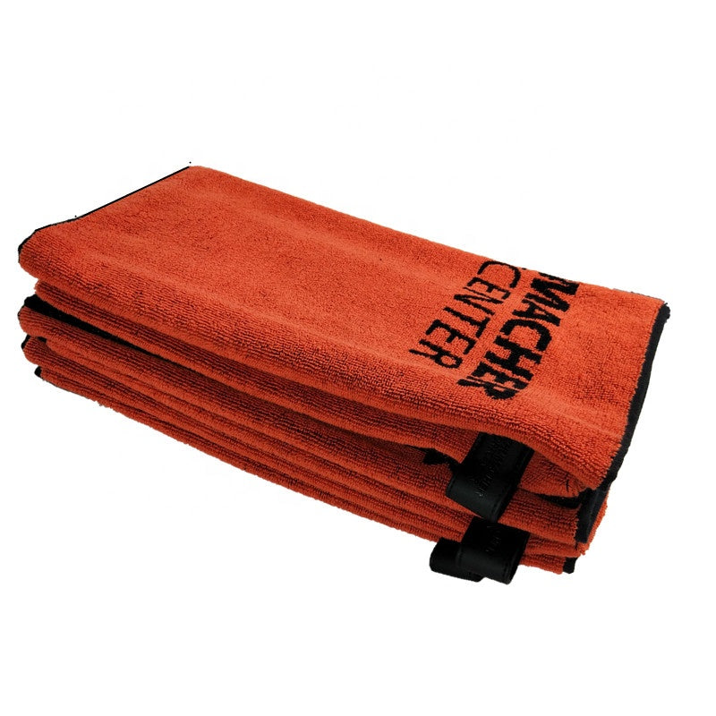 Stack of orange towels with black text on a white background